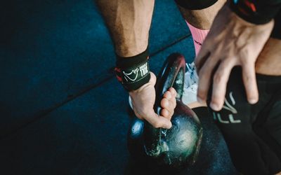 Close-up on an athlete's hands gripping the floor during an exercise.